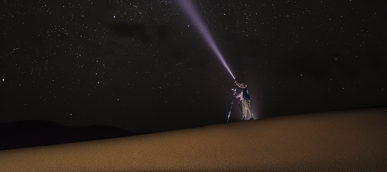 Person with camera and flashlight symbolizes leadership guiding the way.