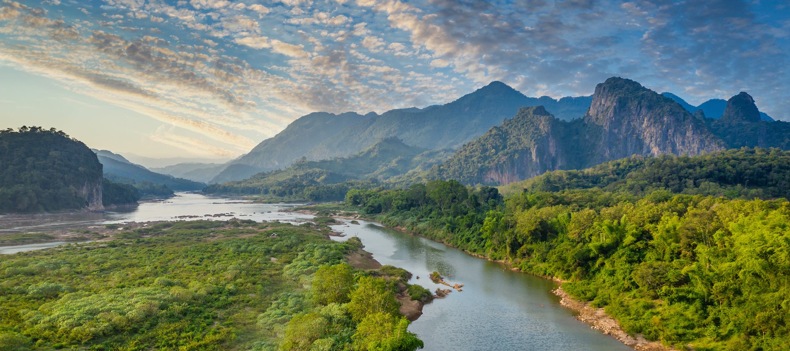 Aerial drone point of view of the beautiful Mekong River under twilight skyscape and a rolling landscape.