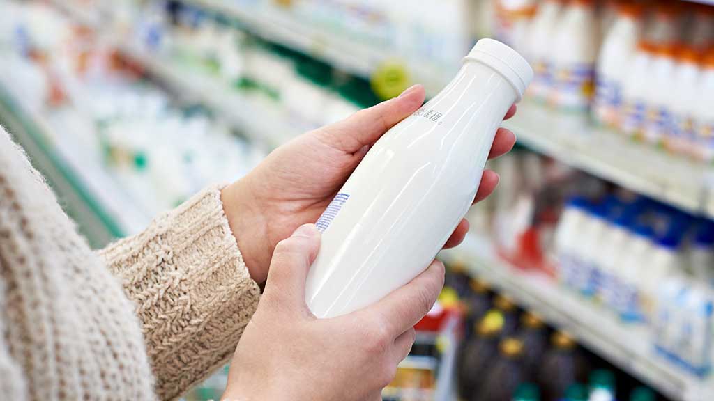 Consumer checks label on bottle in a store