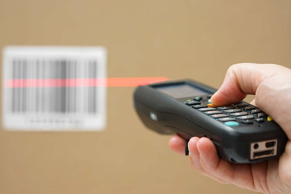 Hand holding bar code scanner and scanning a code