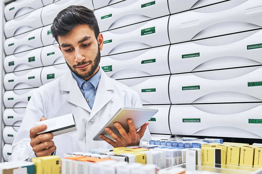 Pharmacist reading label on merchandise at drugstore