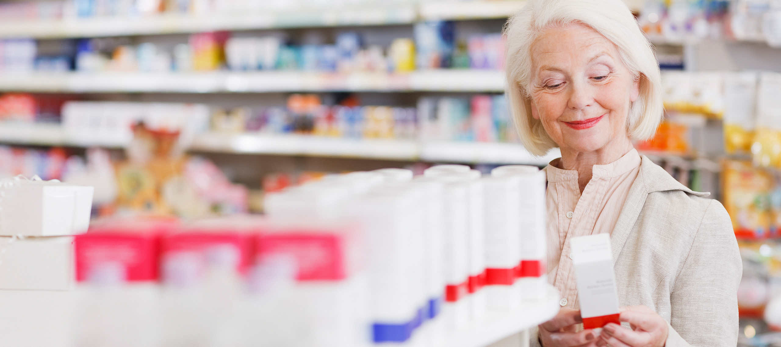 Pharmacist reading label on merchandise at drugstore