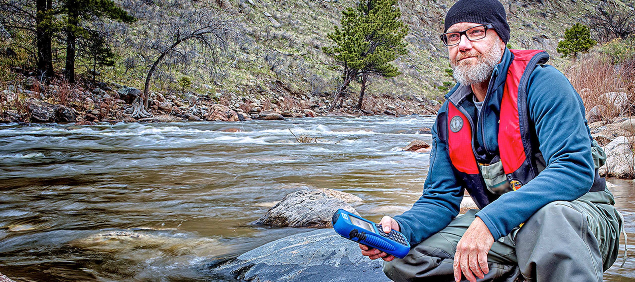 Hach Associate sampling water in a stream